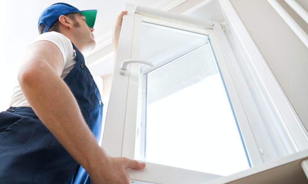 Professional handyman installing window at home.